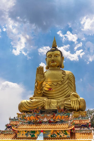 A vertical shot of the golden Buddha statue in a buddhist temple in Thailand.