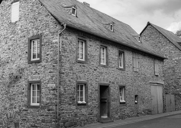 A greyscale shot of a little old house in the center of the town of Cochem