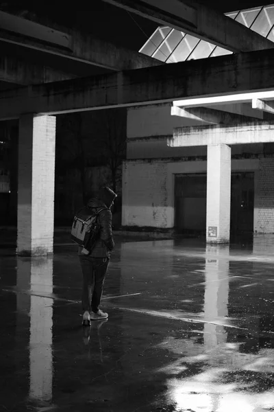 A man with a hoodie standing in a puddle in a lost place in Duisburg, Germany