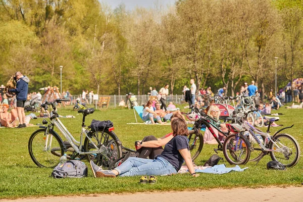 The women resting on green grass next to their bicycles in the park in Poznan, Poland
