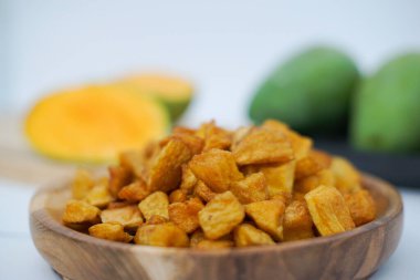 A closeup shot of potato chips in a wooden bowl