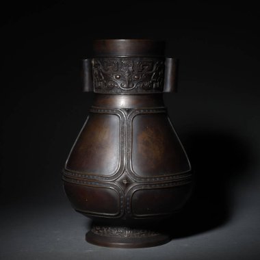 Karanlık bir arka planda izole edilmiş eski bir Çin kavanozunun yakın çekimi.