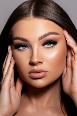 Güzel makyajlı çekici bir kadın modelin dikey çekimi.