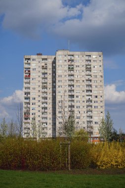 A vertical shot of tall apartment blocks near a green grass field in the Orla Bialego district
