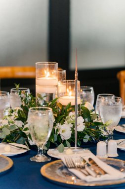 A selective focus shot of a restaurant table with white candles and a numbered sign