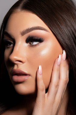 Güzel makyajlı çekici bir kadın modelin dikey çekimi.