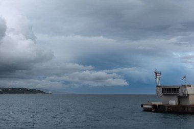 The part of the building on the shore against the cloudy sky and the sea. Monte Carlo, Monaco.