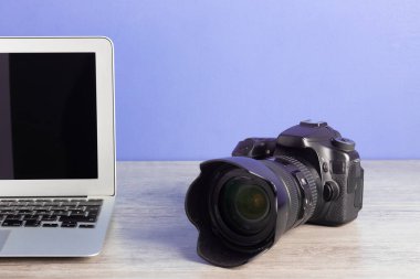 The photographer workstation with a camera on the wooden table