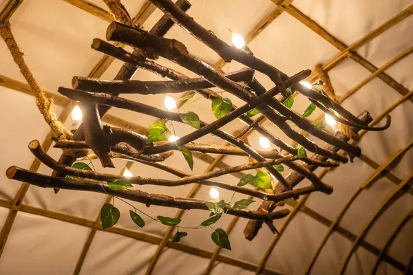 A closeup of a lamp made of tree branches