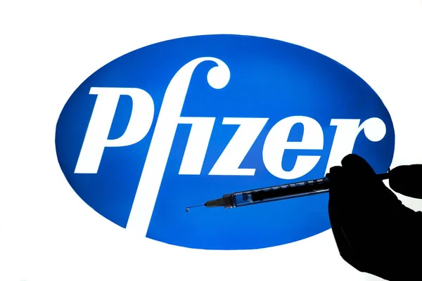 Pfizer Logo Illuminated Computer Screen Silhouette Hand Holding Hypodermic Needle — Stockfoto