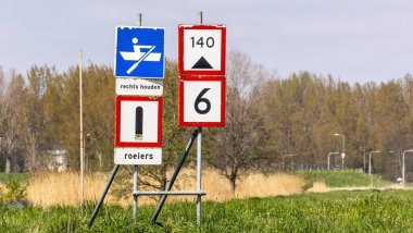 A closeup of street signs near a field