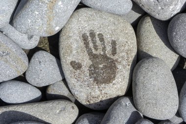 A closeup of the handprint on the stone under sunlight.