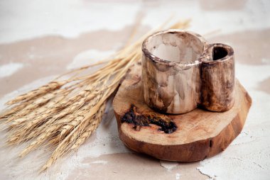 A closeup shot of an old ceramic mug with wheat on a wooden surface