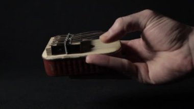 A hand playing DIY handmade Kalimba, made out of vintage can of sardines