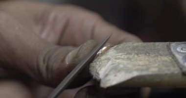 Jakarta, Indonesia-June 19,2022: a traditional goldsmith forms a ring with a hone