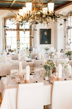 A vertical shot of the interior of a wedding venue with an arranged dinner table