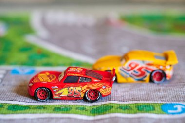 Disney Pixar Cars filmindeki oyuncak model arabalar oyun mat üzerinde.