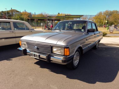 Argentina, Argentina - May 08, 2022: Old beige Falcon Ghia four door sedan 1982 parked in the street. Expo Fierro 2022 classic car show. Copyspace