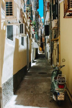 A vertical shot of small narrow street on the island of Corfu with a summer day