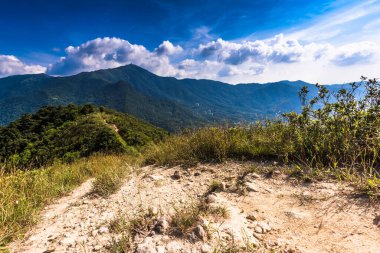 Arka planda bulutlu gökyüzü olan güzel bir dağ manzarası.