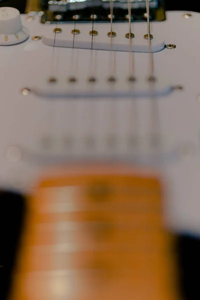 A selective focus shot of the top pick-up of white upside-down electric guitar