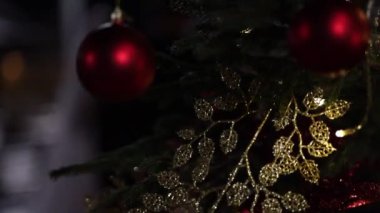 A selective focus shot of Christmas ornaments and decorations around a Christmas tree