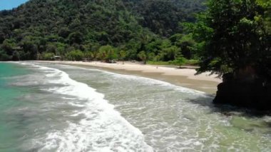 An aerial view of the waves splashing on the sandy beach in summer