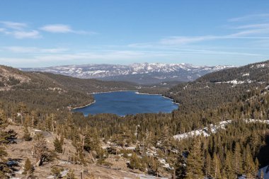 An aerial view of the Donner Lake in bright sunlight against blue sky in Sierra Nevada Mountains, California, United States