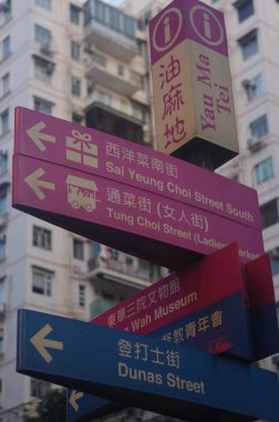 A vertical closeup of street signs in Chinese and English in Hong Kong, Asia