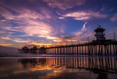 A beautiful view of a bridge over the reflective water of the sea during sunset
