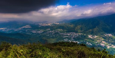 View of a natural landscape with mountains and plants, and clouds in the sky