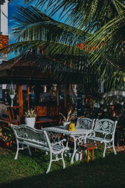 An outdoor cafe with white table and chairs on a sunny day