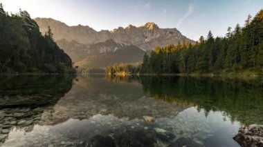 Timelapse of lake Eibsee in bavaria, germany with the mountain Zugspitze in the background at sunrise in summer.
