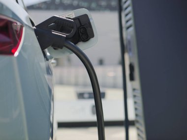 A closeup shot of an electric car being charged at a station