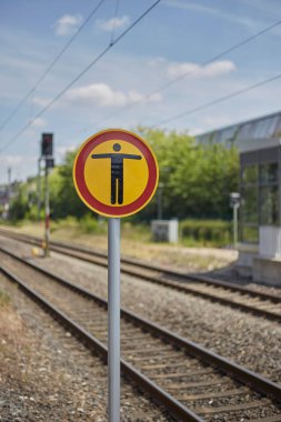 A shallow focus of a caution sign for the pedestrians at the train station