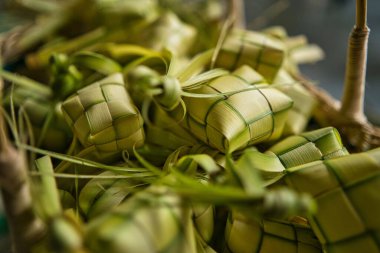 A closeup of a bunch of Ketupat - a rice cake made by weaving the coconut leaves in a basket
