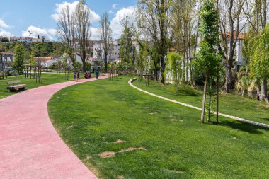 A beautiful shot of people walking on a pathway in Almonda park in the city center of Torres Novas in the district of Santarem, Portugal