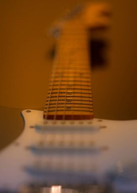 A vertical closeup shot of details on the strings of an electric guitar