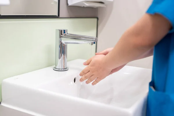 A closeup shot of the doctor washing hands  before examining the g patient's body