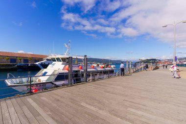 A white Passenger ship leaving the port of Vigo towards the Cies Islands at the day under cloudy sky