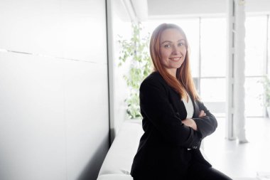 A portrait of a happy cheerful woman in her office