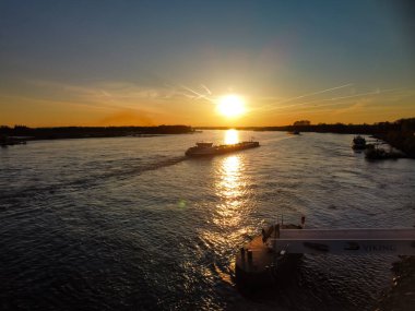 The high angle shot of a travel boat on a lake water at sunset