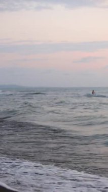 Köpük dalgaları kumlu bir sahile vuruyor