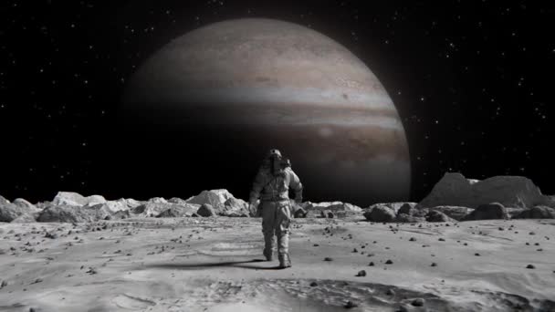 地球に向かって月を自信を持って歩くスーツの勇敢な宇宙飛行士の映像木星 — ストック動画