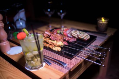 Bir tabak tavuk ve sığır barbeküsü yanında da bir bardak taze mojito.