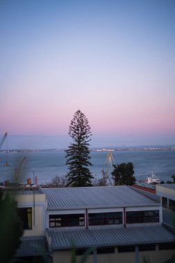 A vertical shot of a town on the shore at sunrise