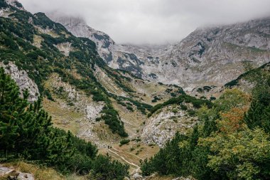 Karadağ 'ın güzel dağlarında gri bulutlu gökyüzüne karşı bir yürüyüş patikası