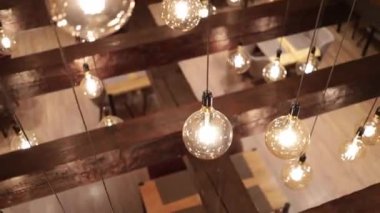 A selective focus shot of light bulbs hanging from the ceiling as decoration for a celebration party