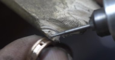 Jakarta, Indonesia-June 19, 2022: The process of making gold rings by traditional craftsmen by making holes in the ring for the ring eye
