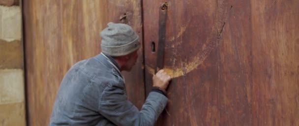 古い木造の教会のドアをノックし エジプトの鍵穴を通して見る男 — ストック動画